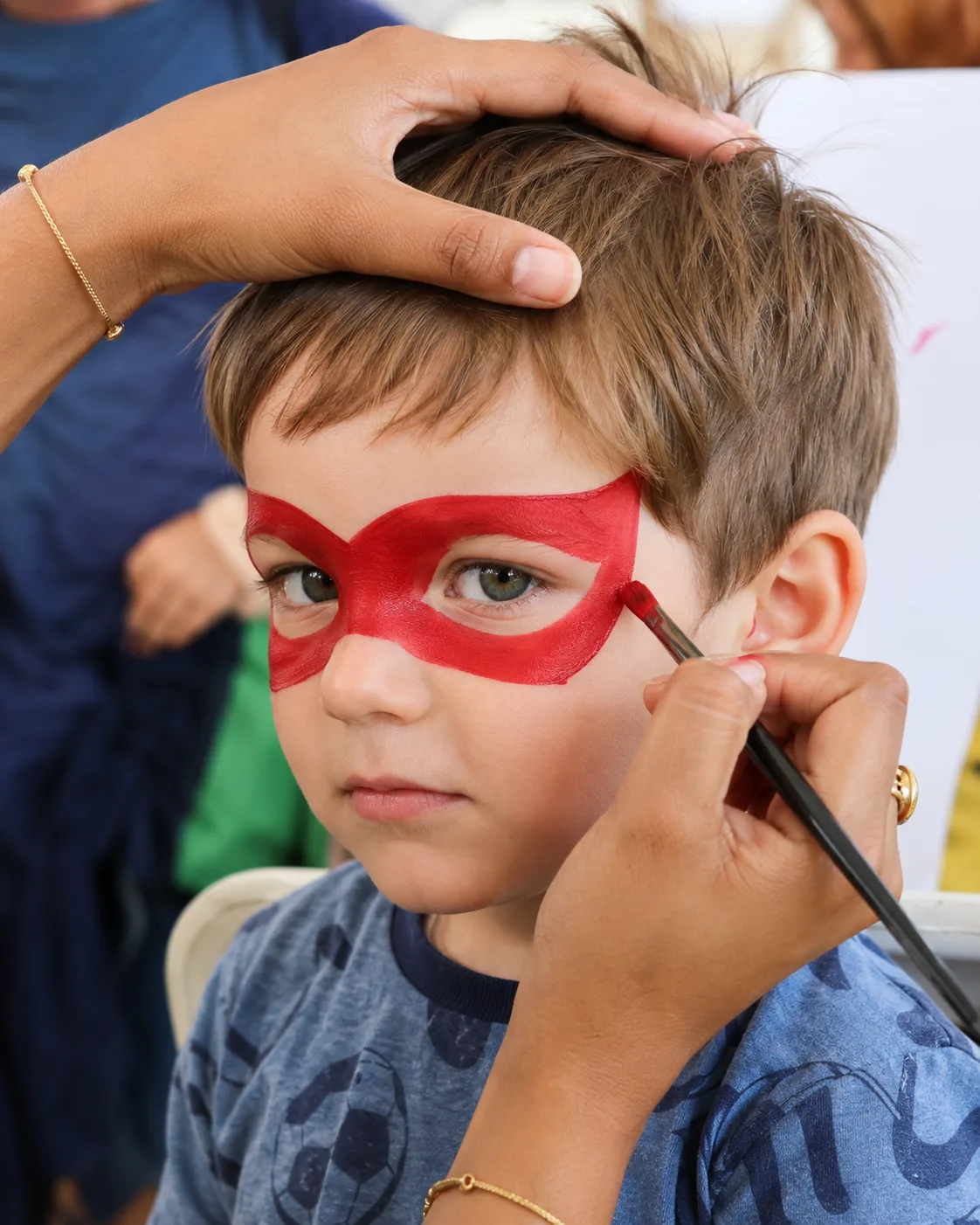 Piya's superhero mask face-painting design on a child